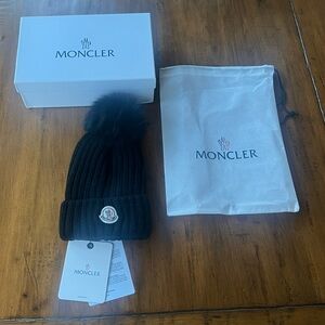 Moncler Black Ribbed Beanie with a Faux Fur Pom Pom. New with tags and box.